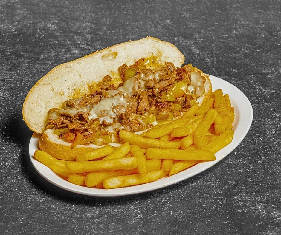 Classic Philly cheesesteak sandwich with fries at Play By Play