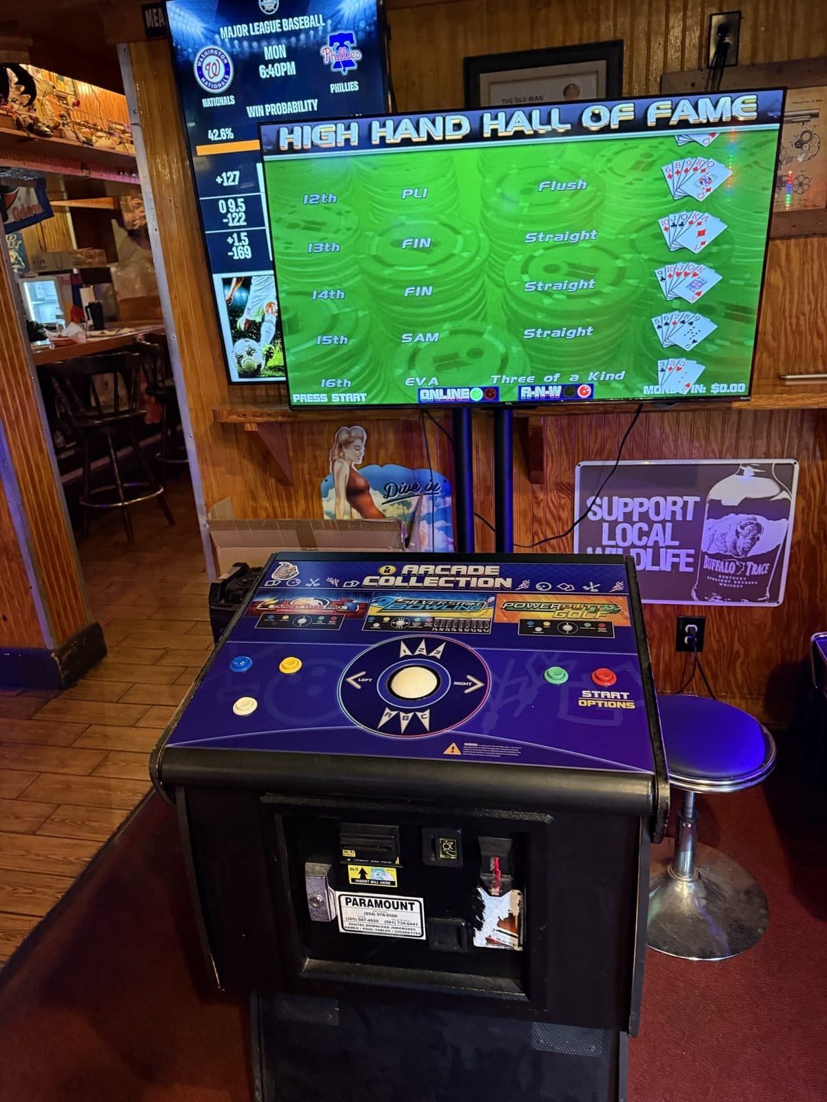 Arcade Collection cabinet under a wall-mounted TV at Play By Play Sports Bar
